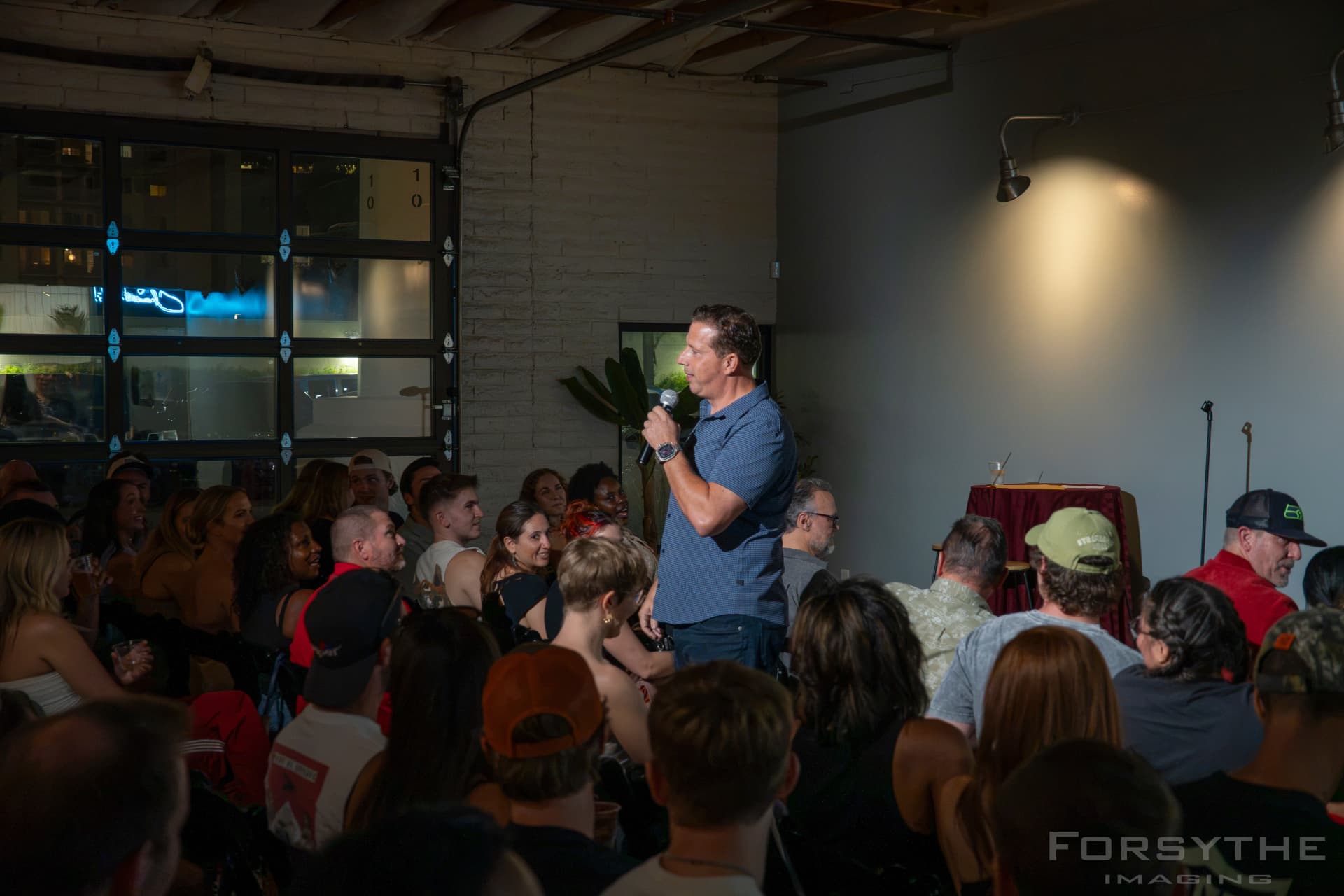 Host standing in the middle of the audience doing crowd work