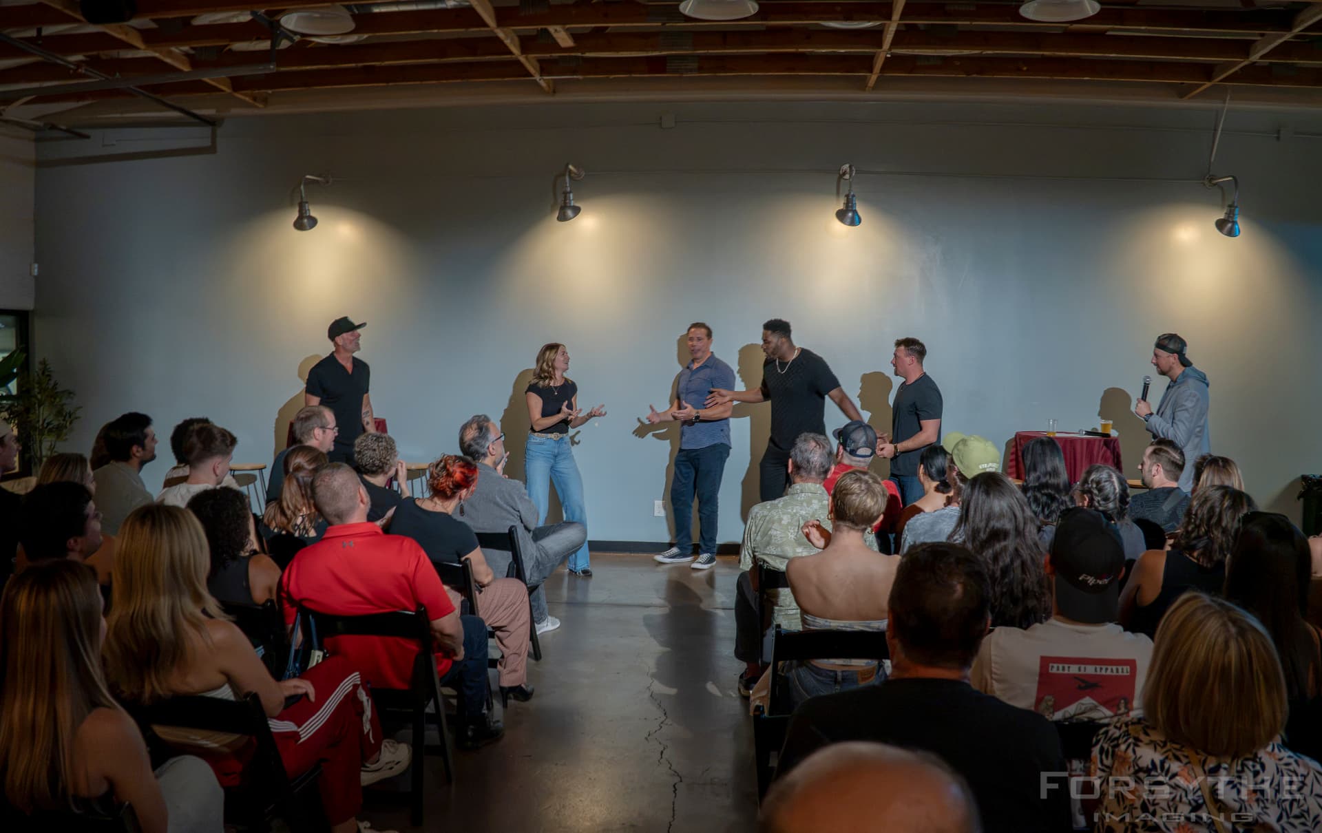 Improv troupe playing a scene in front of a packed room