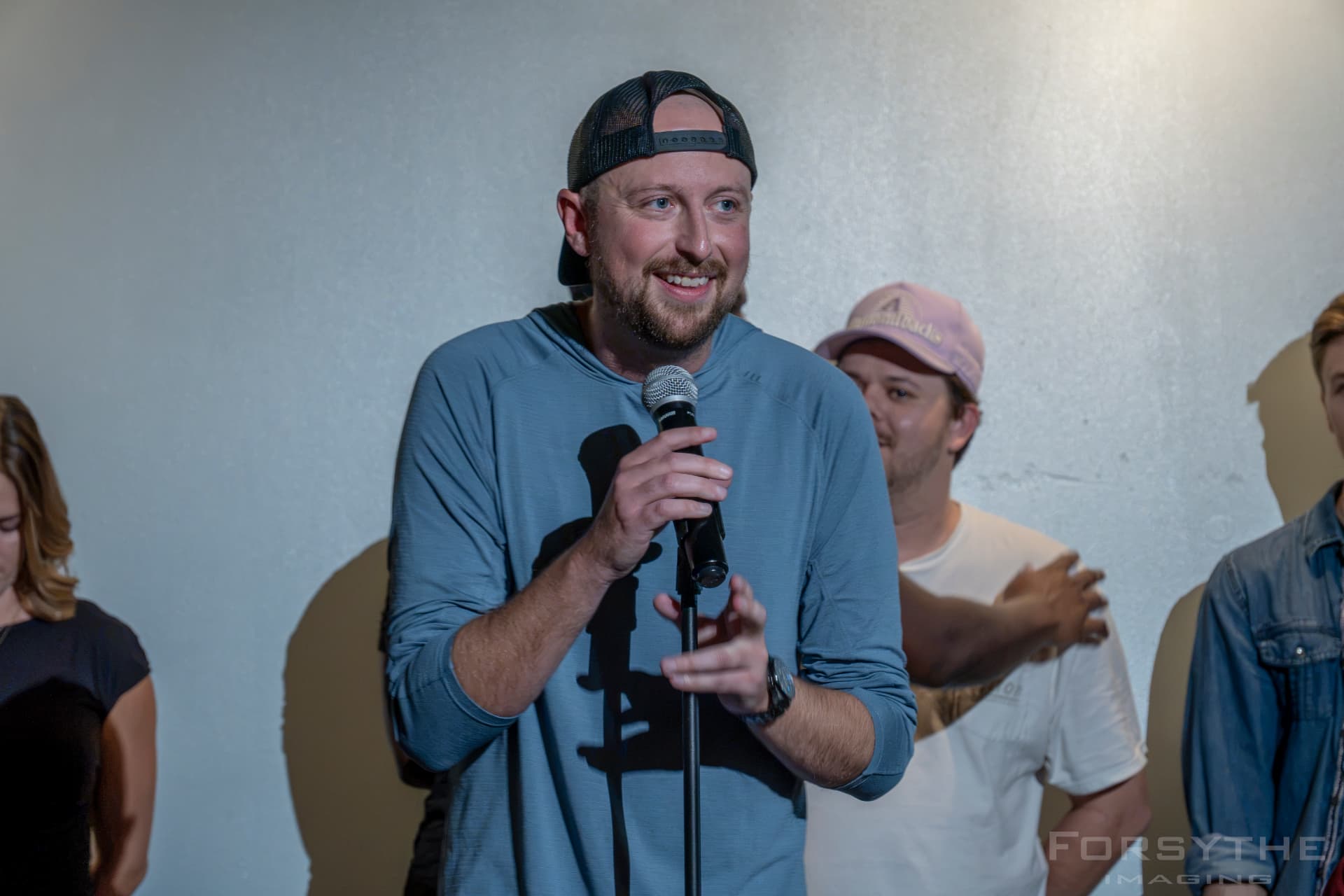 Host smiling at the mic stand